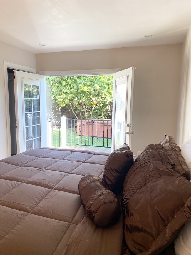 Primary suite w: king size bed & French doors opening to hot tub in the back yard - 1350 Curson S Ave