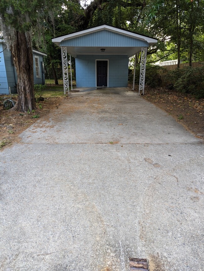 Covered carport with plenty of room for a second car in the fenced driveway. - 4107 Crane St