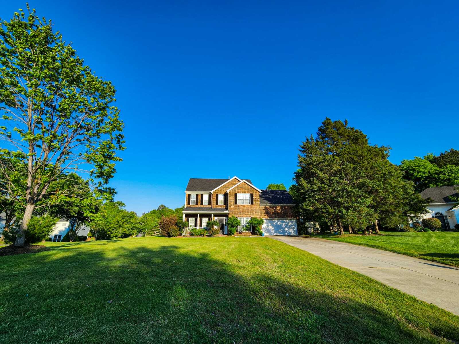 Full front view with long driveway and spacious front lawn. - 7801 Peach Blossom Ct