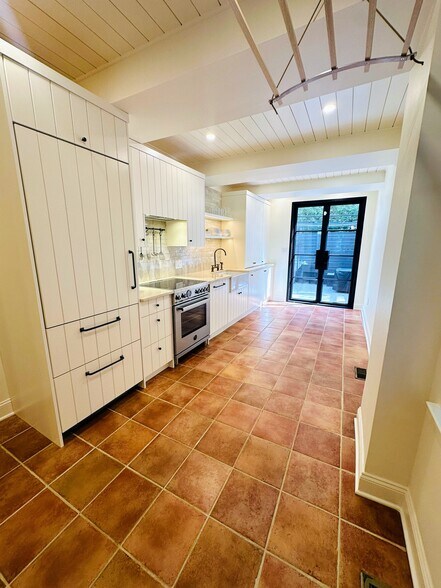 Kitchen with custom cabinets, brand new paneled refrigerator and dishwasher, induction range - 615 S Bambrey St