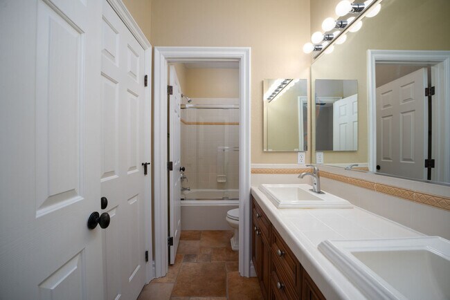 Dual vanity bath in jack-n-jill configuration serves 2nd and 3rd bedrooms - 2850 Bronzino Ct