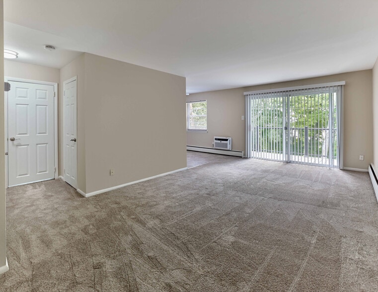 Expansive living area with wall-to-wall carpet and private balcony at Maple Terrace Apartments in Maple Shade, NJ - Maple Terrace