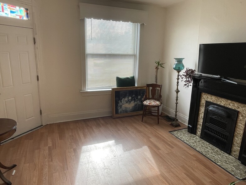 Front, south facing room. Featuring a decorative fireplace and pocket door. - 5313 Magnolia Ave