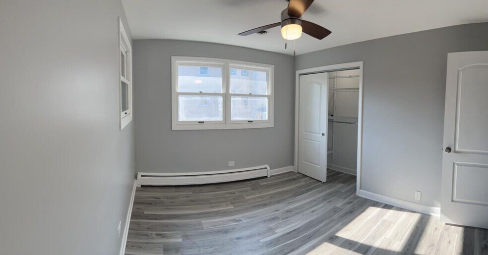 Back bedroom or office with new solid plank flooring, closets, blinds, and fan. - 771 56th St