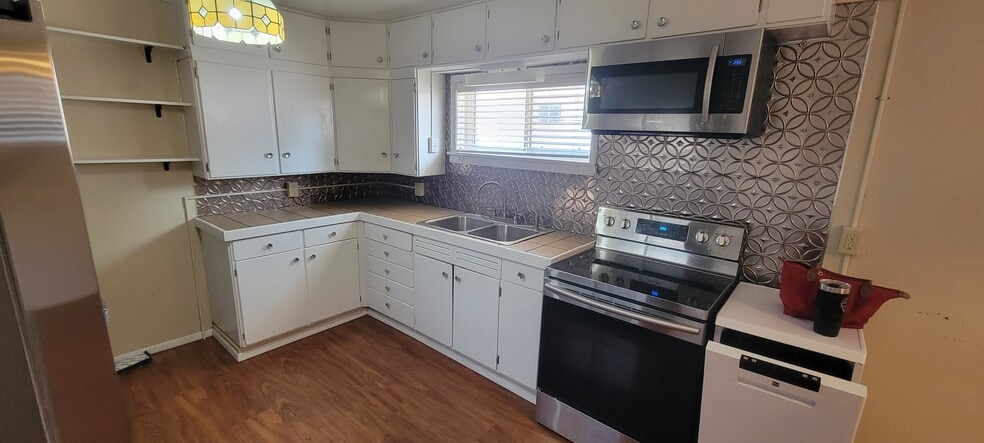 Kitchen counter splash wall features a very retro, decorative metallic covering. Includes refrigerat - 814 Atchison Ave