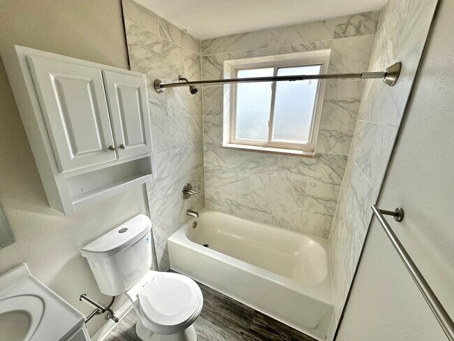 Step into this beautifully designed bathroom with luxurious marble finishes. - Allison West Apartments
