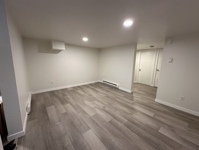 Living room with kitchen on the left and hallway leading to 3 bedrooms and a storage room on the rig - 1137 E Platte Ave