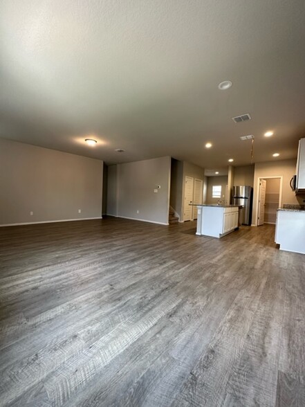 View of kitchen from family room with wood finish floors - 2130 Dry Moss Pass