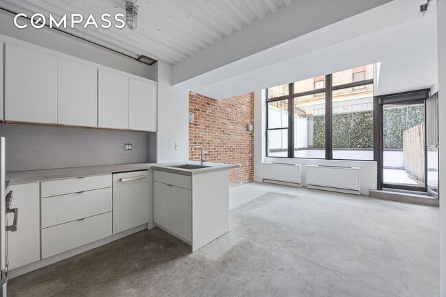 Building Photo - Loft-style one-bedroom with double-height ceilings, oversized windows, and private garden in the ...