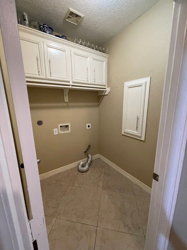 Laundry room with custom wood cabinets gas dryer connection - 600 River Bend Dr