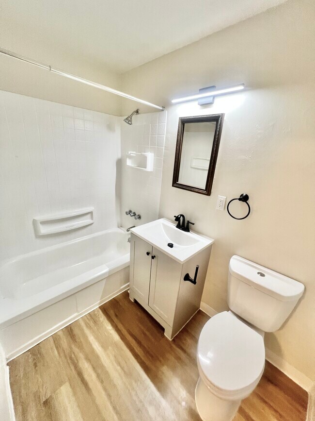 Experience the elegance of this modern bathroom, designed with sleek fixtures and minimalist aesthetics. - Harmony Apartments