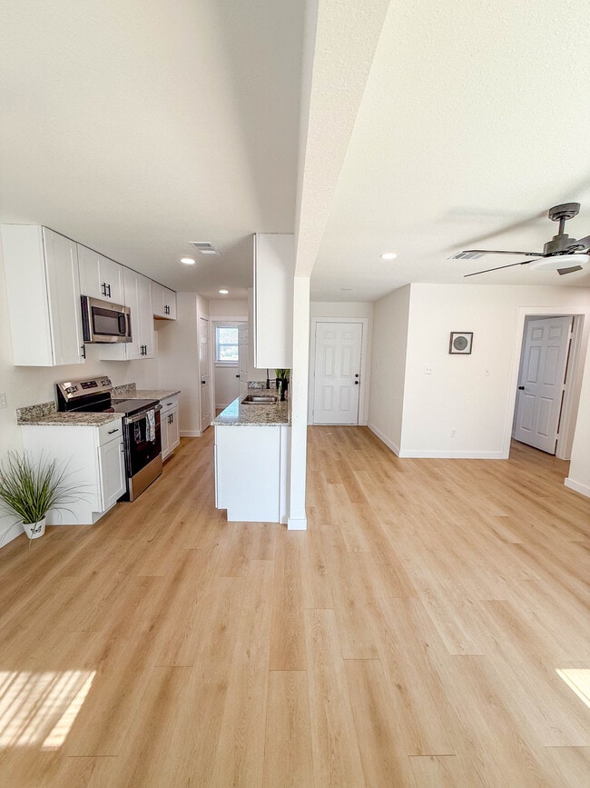 Kitchen with stainless steel appliances leading to separate laundry room. Open floor plan from dinin - 308 E Bourn St