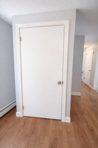 Laundry closet with stacked washer and dryer neatly tucked behind doors - 16 Miller Rd