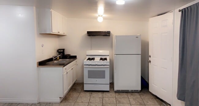 Studio kitchen, equipped with gas range stovetop, oven, & refrigerator - 16208 E Kingside Dr