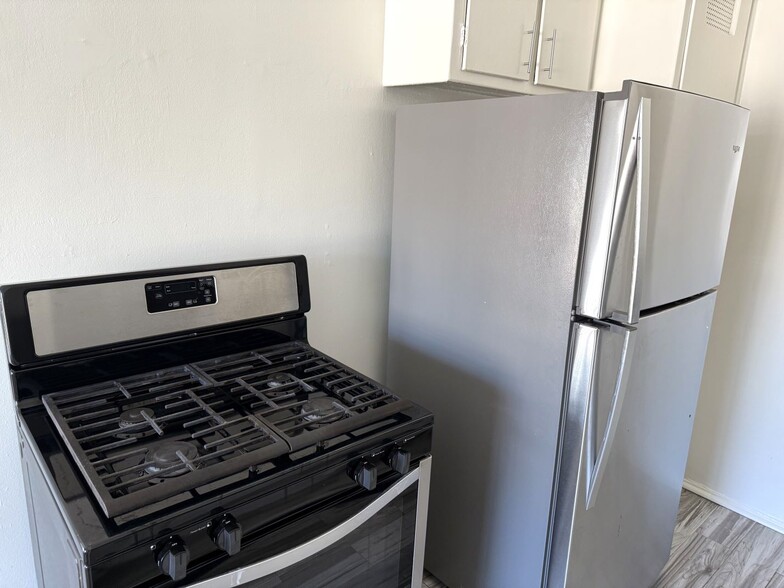 Kitchen with stove and refrigerator - 4445 Murietta Ave