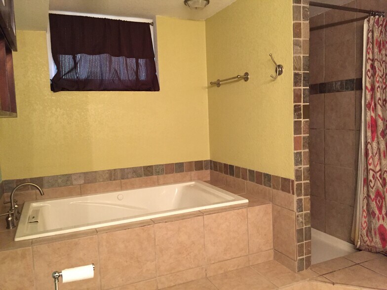 Master bath with jacuzzi tub and grotto-style shower - 4660 Perry St