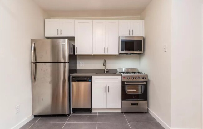 White Kitchen with updated stainless steal appliances - Sedgwick Terrace