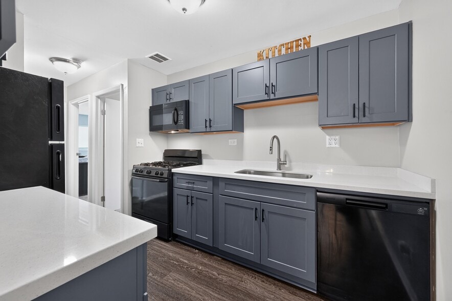 Cook up something great in this stylish kitchen with black appliances and cabinetry at Renaissance at Carol Stream in Carol Stream, IL. - Renaissance at Carol Stream