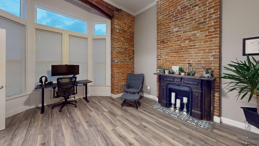 Front Bedroom with exposed brick, original fireplace and view overlooking the 6th Street Promenade. - 127 N 6th St