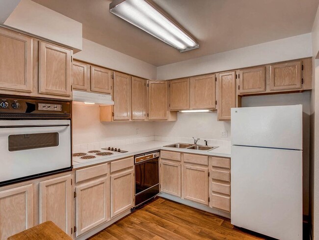 Royal Gardens - Kitchen featuring white appliances, large Formica counter tops, and tan cabinets. - Royal Gardens