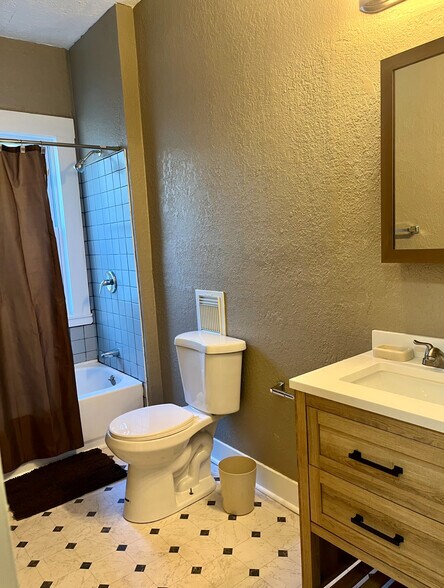 Tiled shower, updated vanity, vinyl flooring. - 603 E 109th St