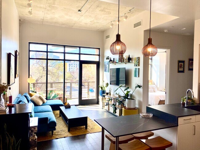 The luminous living area has high ceilings and downtown views. - 1501 E 4th St