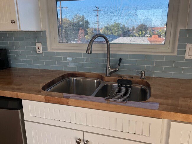 Beautifully sealed butcher block counter tops and 2-tub kitchen sink with disposal. North facing window. - 4470 Swift Ave