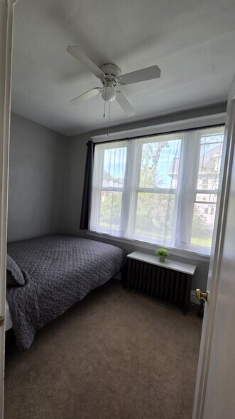 Comfortable front bedroom featuring a Queen bed and large windows for plenty of natural light. - 822 E 4th St