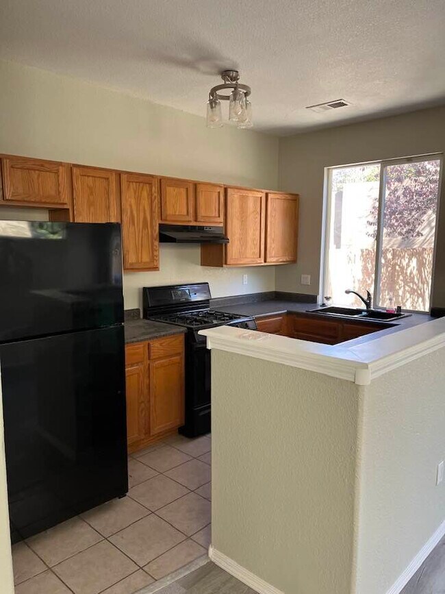 Kitchen includes black refrigerator, stove, and dishwasher. Black sink. - 6501 San Antonio Dr NE