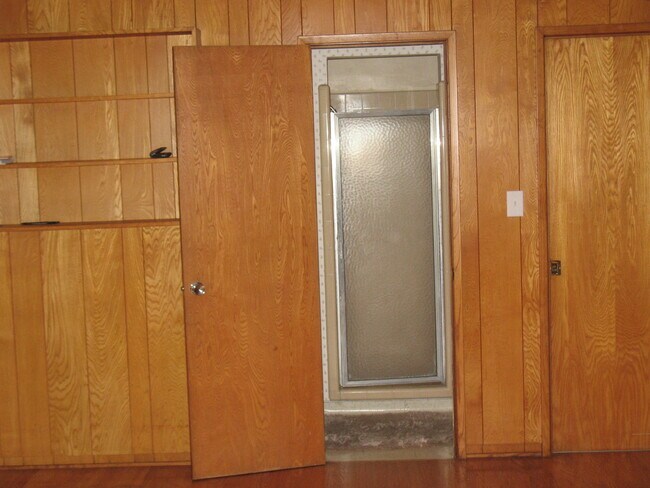 View to bathroom from gigantic wood paneled bedroom with hardwood oak floor; built in bookshelf - 3121 W Wyoming Ave