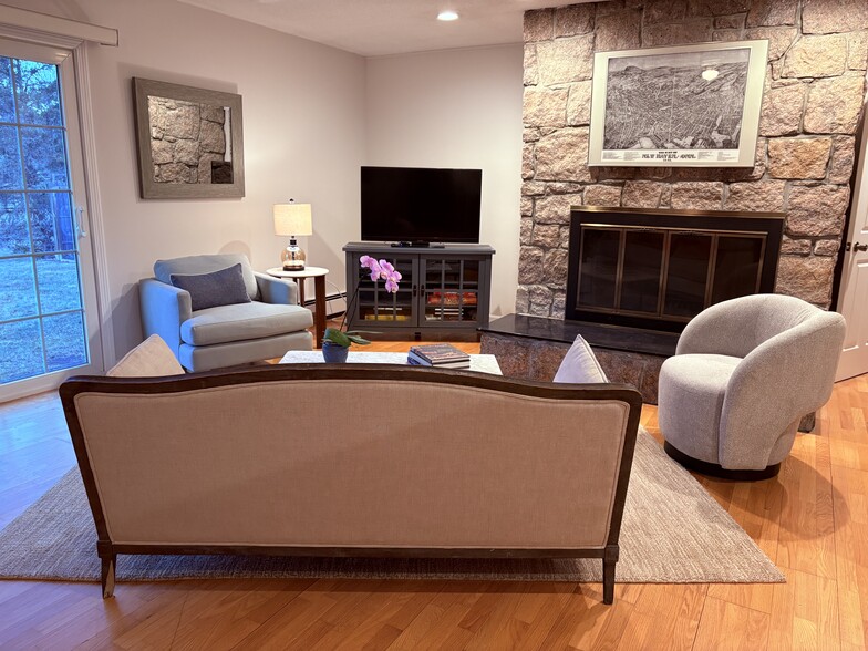 Living room features a Stony Creek granite fireplace, comfortable furniture, TV with Roku, and board - 683 Richies Way