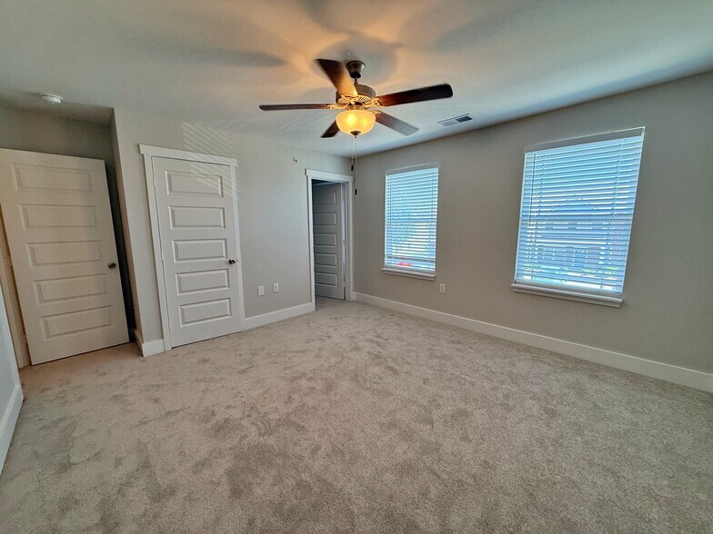 The primary bedroom features large windows and two closets. - 3010 Bellflower Cir