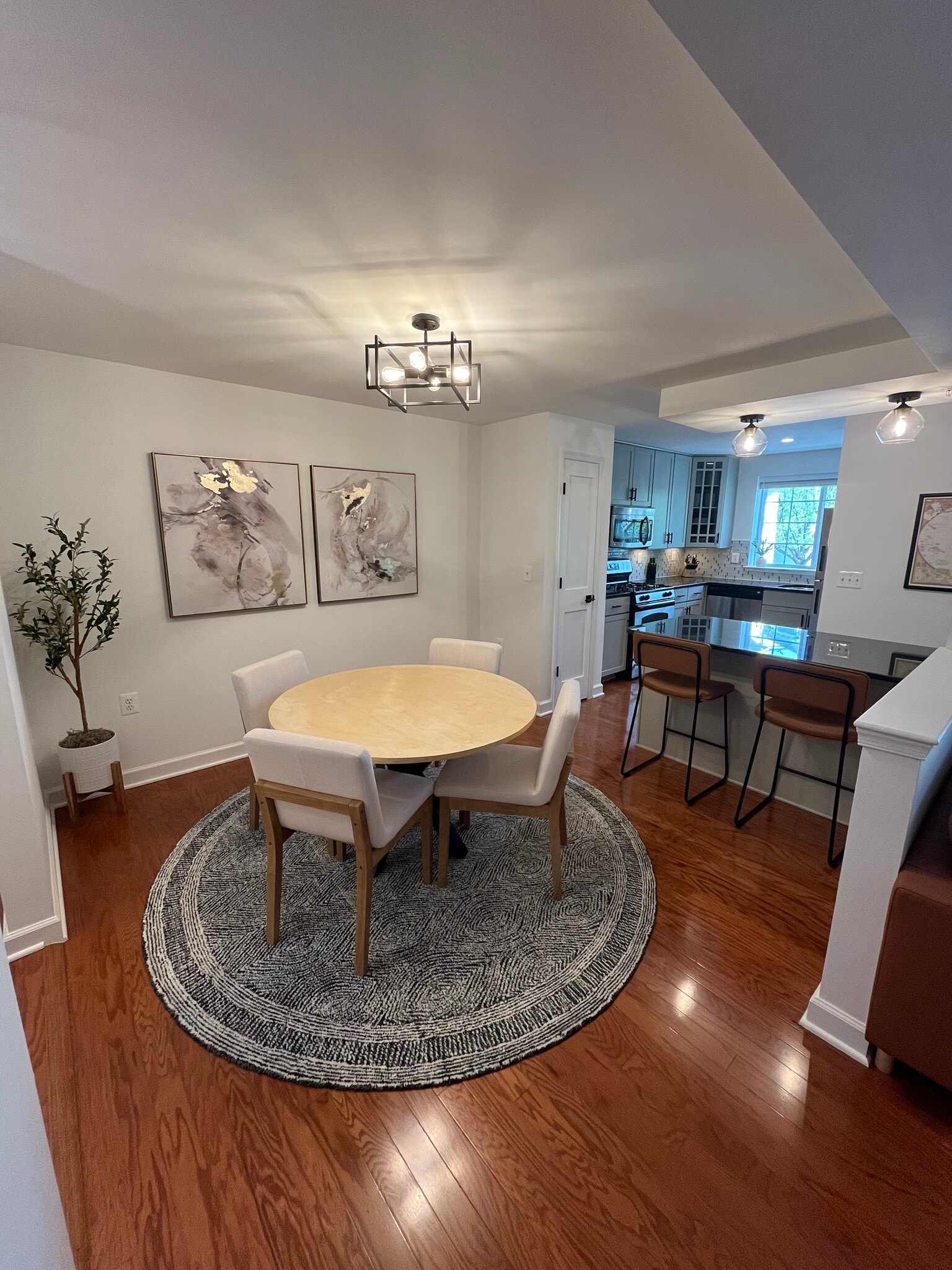 Dining area with space for four under a modern light fixture. - 4079 S Four Mile Run Dr