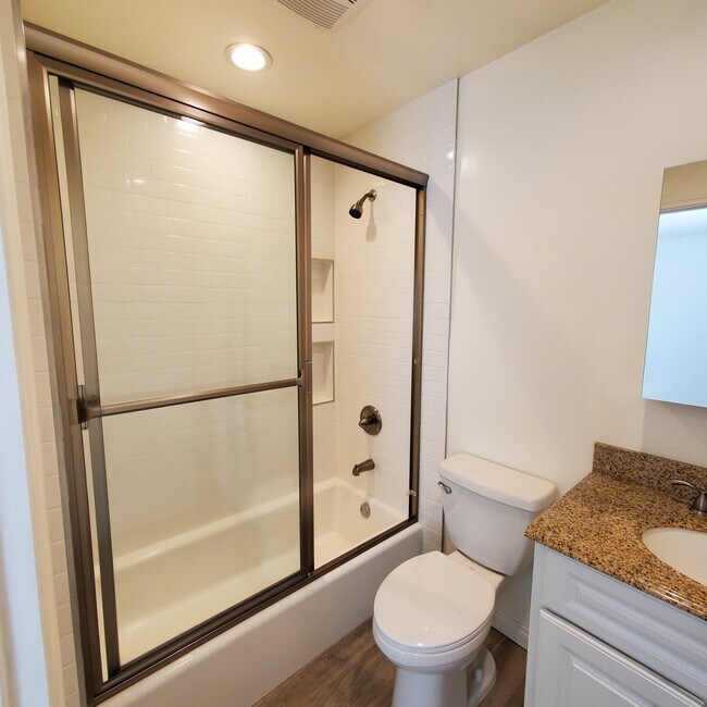Full master bathroom with Kohler mirrored medicine cabinet and tile shower. - 5731 Fulton Ave