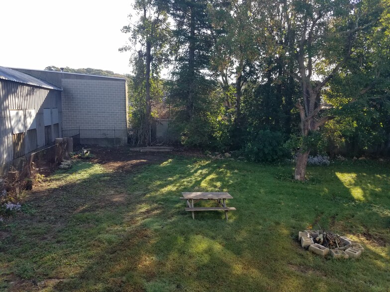 Backyard picnic table and fire pit. Building supply warehouse is next door. - 11 Jay St