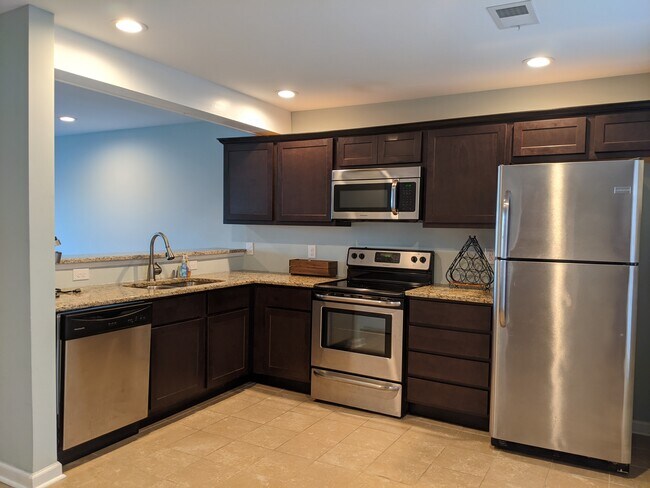 The kitchen includes stainless steel appliances and an open bar top to the living/dining area. - 2414 Lake Park Rd