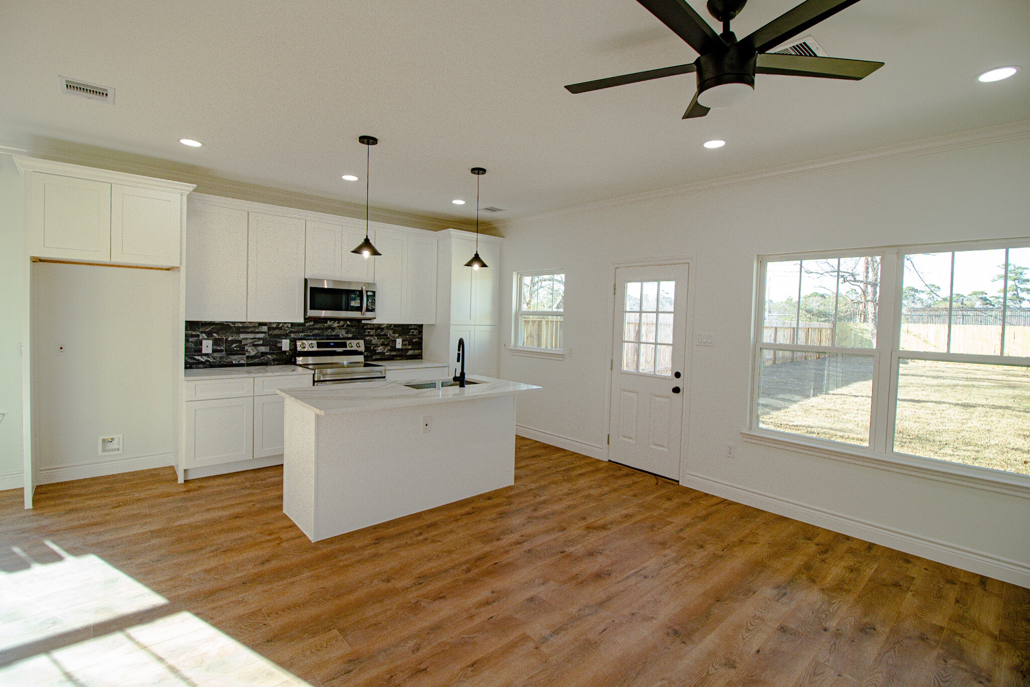 Living room looking into kitchen with stainless steel appliances - 928 W Austin St