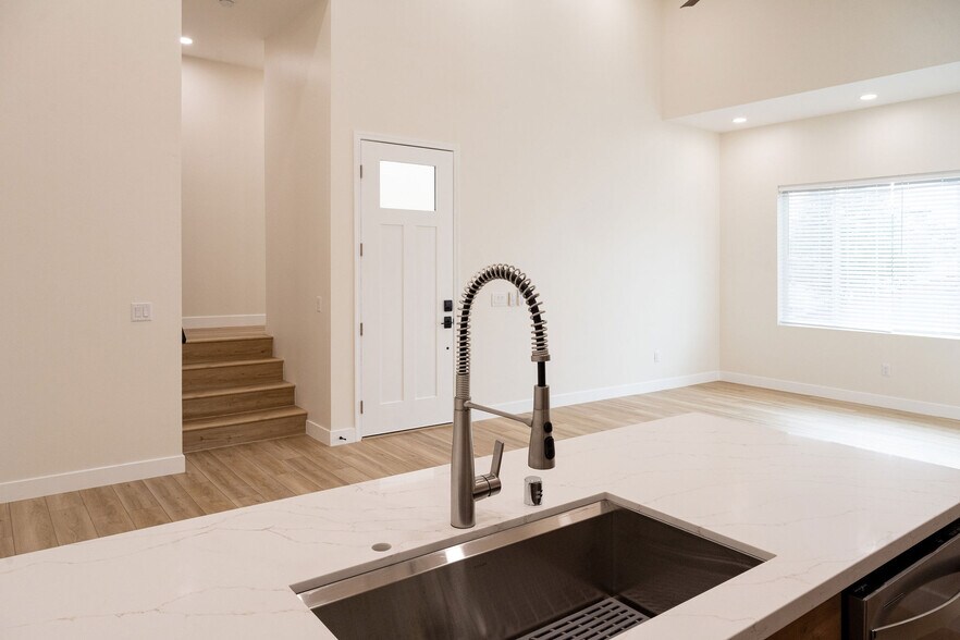 view of living space from kitchen. Stairs lead to bedroom. - 4774 Bancroft St
