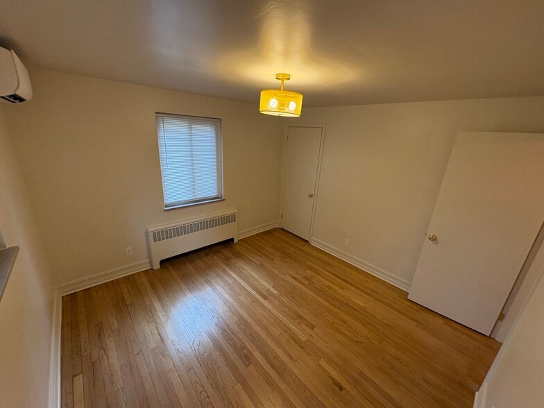 Large bedroom with decorative light fixture - 6035 Oakwood Ave