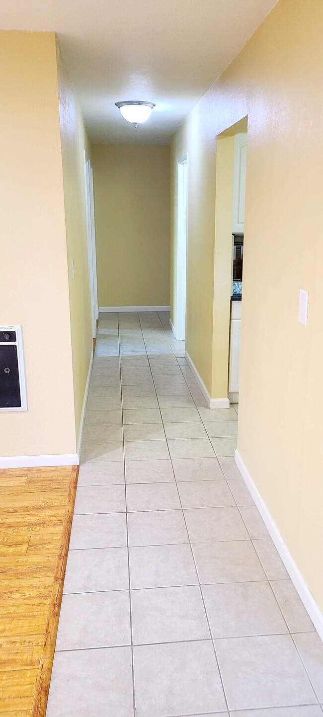 View from the end of the main hallway. Dining nook is directly to the right. Second bedroom and bath - 466 Crescent St