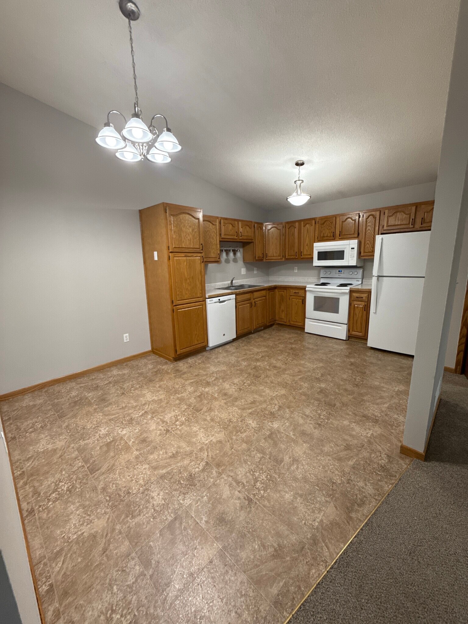 Bright kitchen with abundant oak cabinetry, dishwasher, and generous counter space. - 9092 Goldenrod Ln N