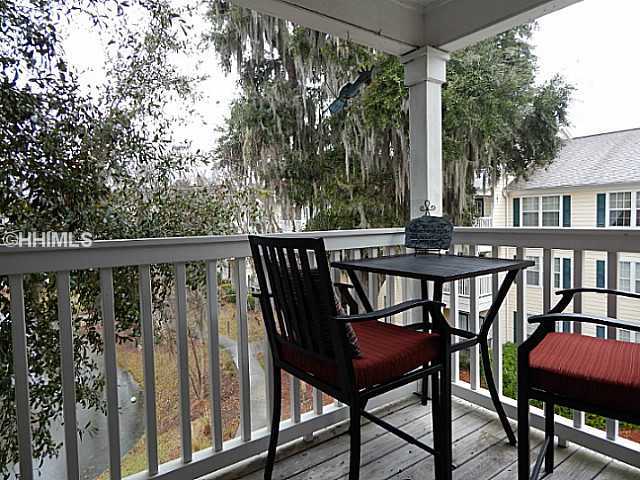 Balcony off living room overlooking tree-lined lagoon - 100 Kensington Blvd