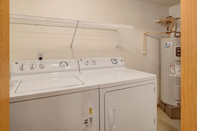 A full size washer and dryer in a closet off the living room next to the water heater - Lake Park