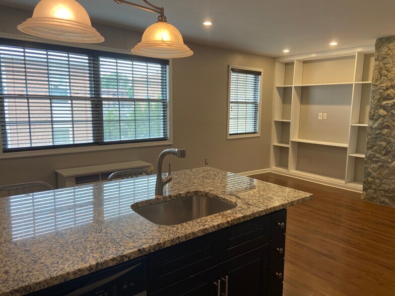 Living room/kitchen/dining with large south-facing windows--perfect natural light on sunny days! - 2576 Sherman Ave NW