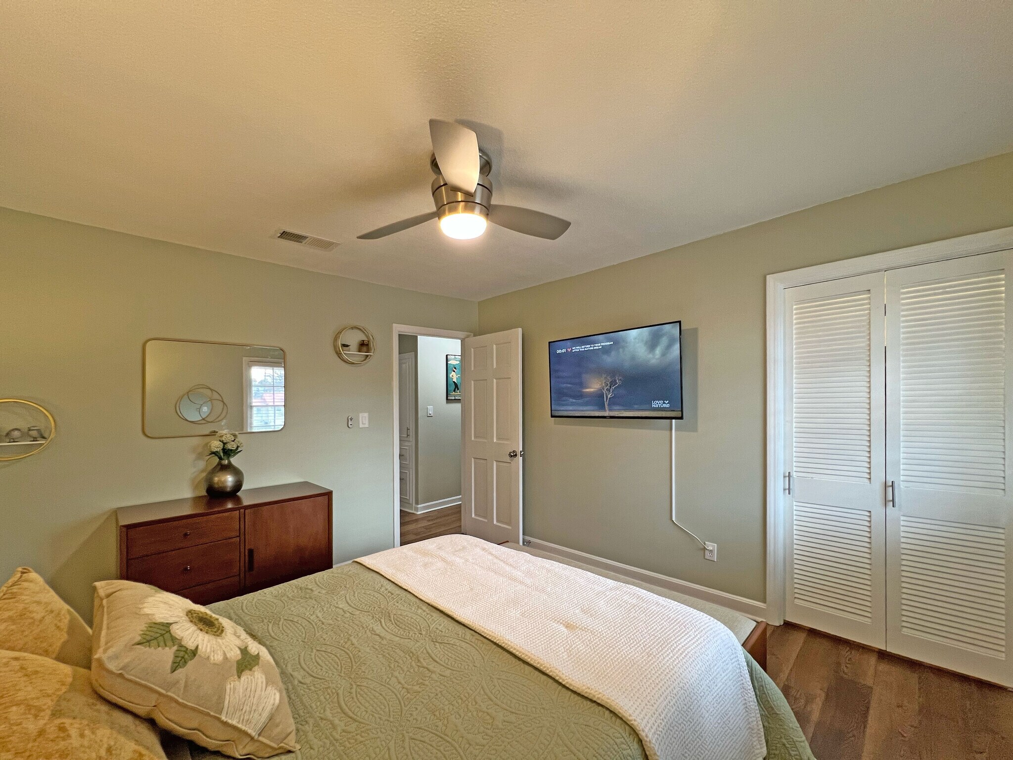 Queen bedroom featuring a 55" smart TV w/Roku, ceiling fan w/remote & comfortable dual bedside light - 160 17th Street Pl NW