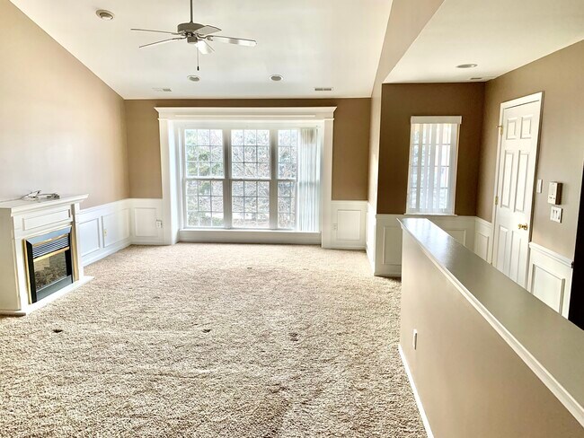Living room with high ceilings and an electric fireplace. Crown molding throughout. - 51870 Adler Park Dr E