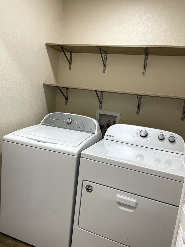 Laundry space behind accordion doors with more shelving - 12838 Arezzo Cir