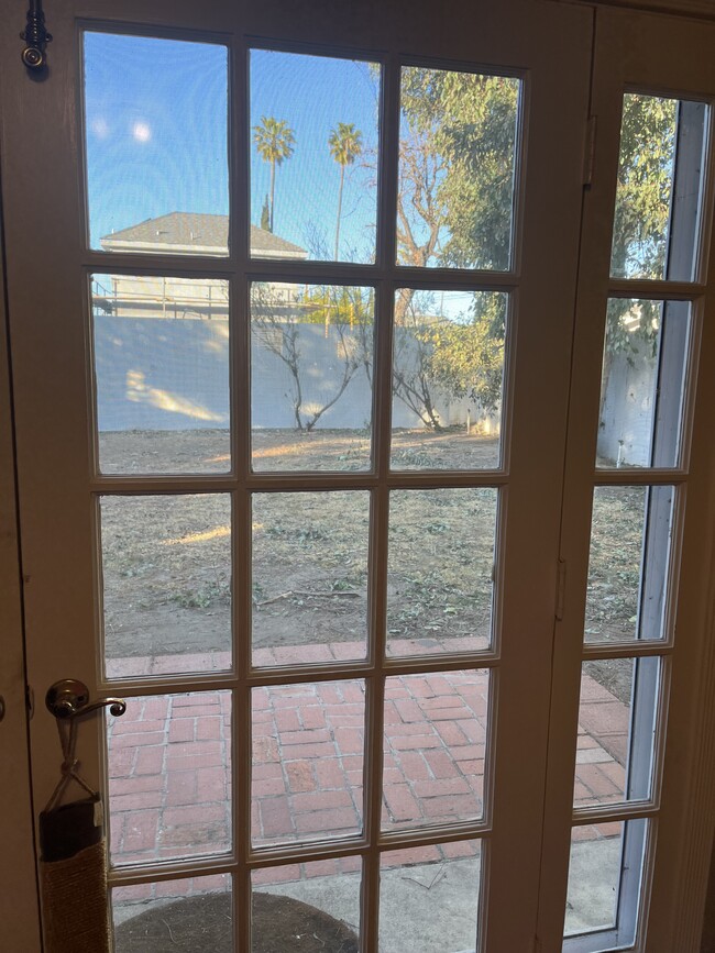 French doors to fenced back yard with brick & cement patio - 14131 Chandler Blvd