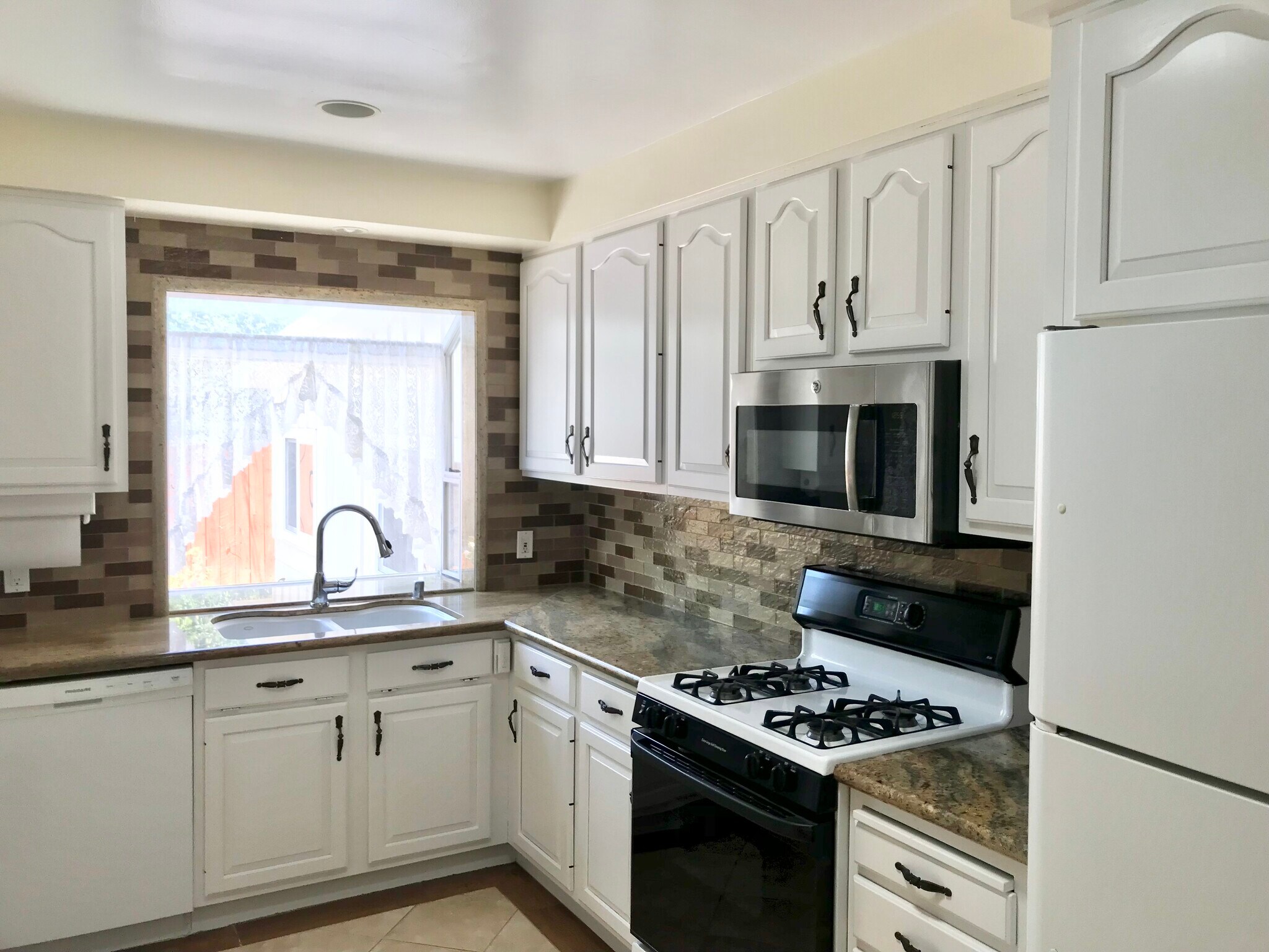 Fresh & Functional Kitchen with backyard access & sunny view of patio. - 11237 Garfield Ave