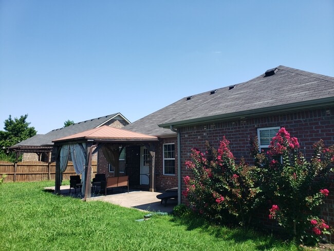 Lovely fenced back yard with beautiful tin roofed gazebo and additional concrete pads for furniture. - 820 Laramie Ct